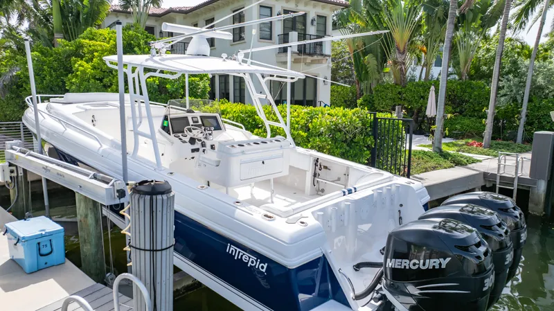  Yacht Photos Pics 2008 Intrepid 370 Cuddy boat docked, featuring dual Mercury engines, surrounded by lush greenery.
