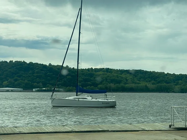 4817rf Yacht Photos Pics Sailboat Tartan 101 (2013) on calm water near a wooded shoreline.