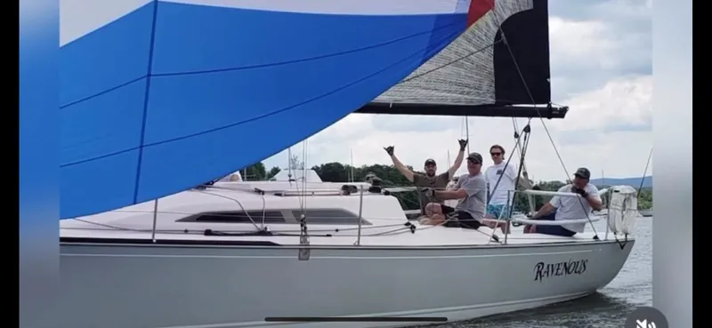 4817rf Yacht Photos Pics Sailboat Tartan 101, 2013 model, with crew sailing on a lake under a blue spinnaker.