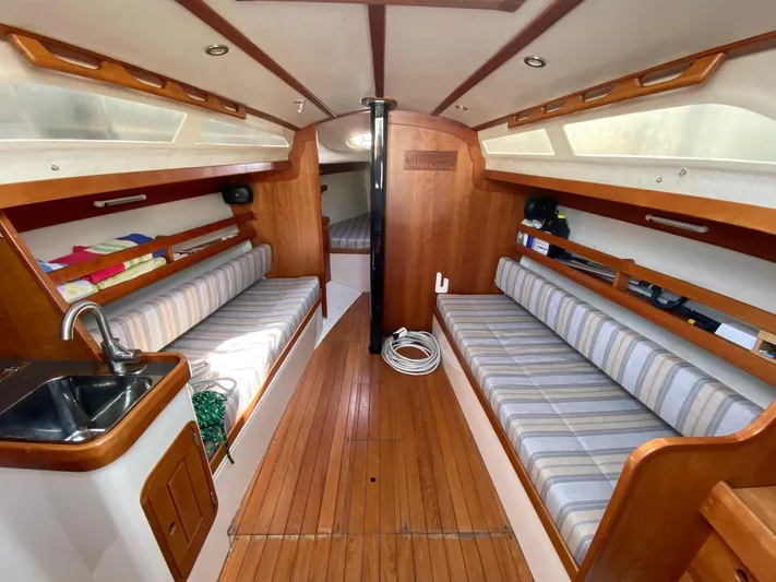 4817rf Yacht Photos Pics Interior of a 2013 Tartan 101 sailboat with wooden flooring and striped seating.