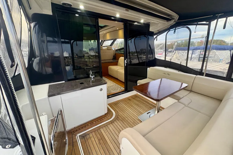 Skalywag VI Yacht Photos Pics 2015 Sea Ray 470 Sundancer yacht interior with seating, table, and kitchenette.