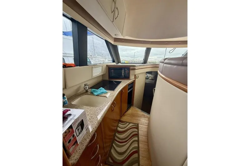  Yacht Photos Pics Interior of 2004 Carver 450 Voyager Pilothouse, featuring a compact kitchen area with sink and appliances.