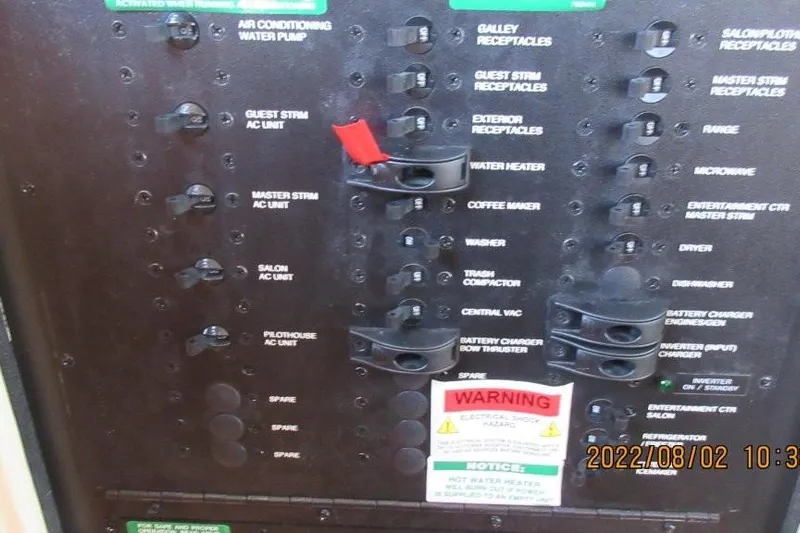  Yacht Photos Pics Electrical panel of 2004 Carver 450 Voyager Pilothouse with labeled switches and warning signs.