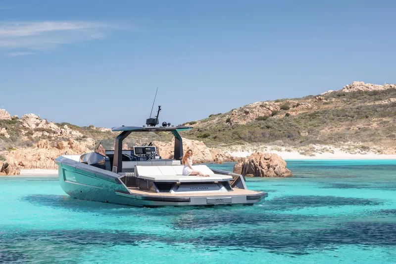  Yacht Photos Pics Luxurious 2026 Maori yacht anchored in crystal-clear turquoise waters near rocky coastline.