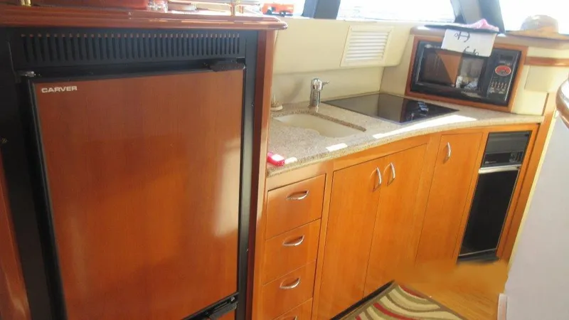  Yacht Photos Pics 2004 Carver 450 Voyager Pilothouse kitchen with wood cabinetry and modern appliances.