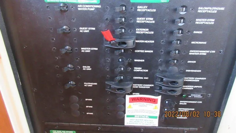  Yacht Photos Pics Electrical panel of a 2004 Carver 450 Voyager Pilothouse with labeled switches and warning notice.