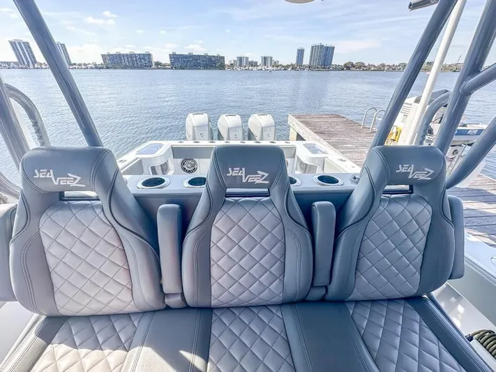Fortuna Yacht Photos Pics 2021 SeaVee 370z boat interior with three quilted seats, overlooking a waterfront cityscape.