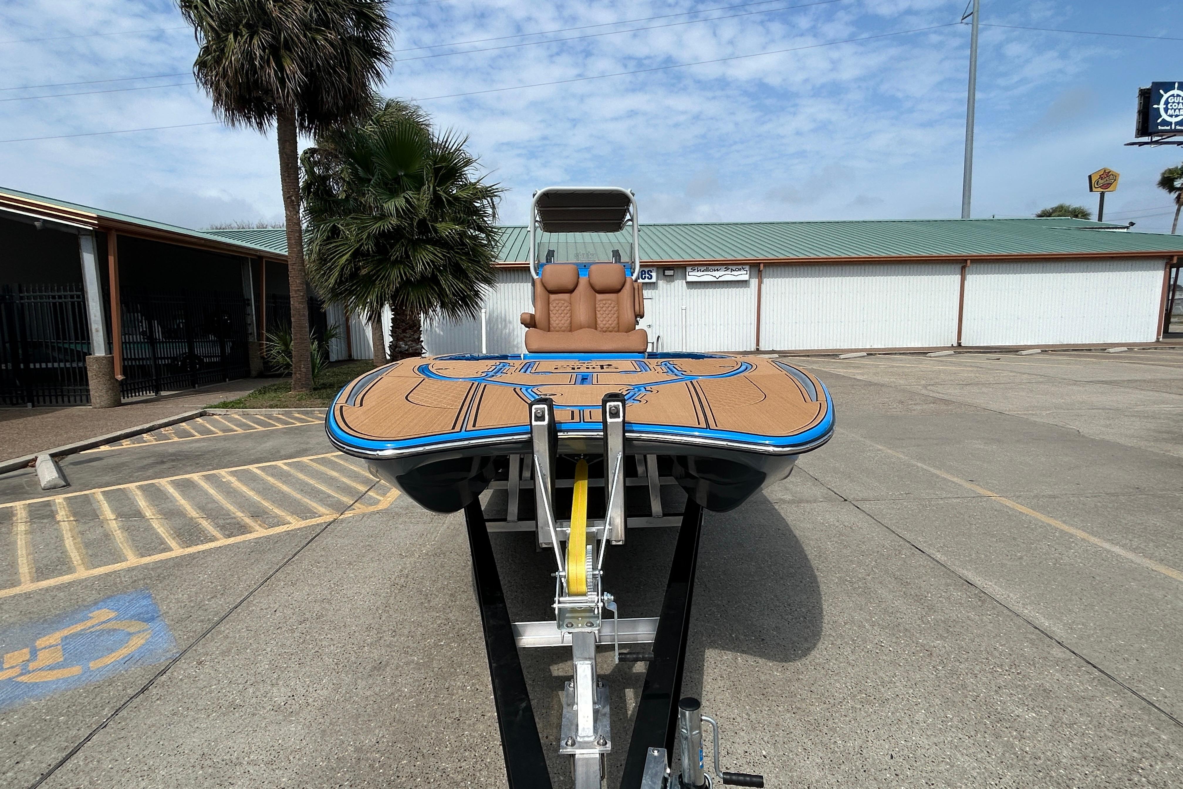 2026 Skuta 24 Skuta Cat boat on trailer, parked outdoors with palm trees.