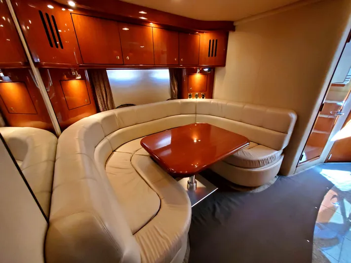 Sunbear Express Yacht Photos Pics Luxurious interior of 2001 Sea Ray 510 Sundancer yacht with elegant seating and wooden table.