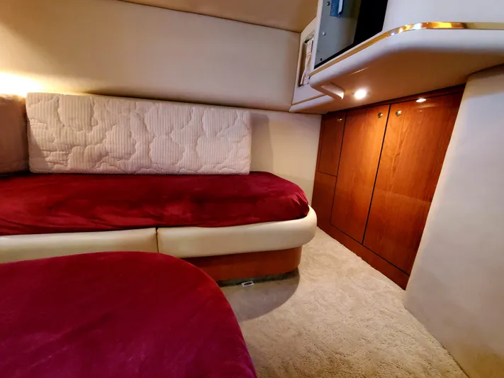Sunbear Express Yacht Photos Pics Interior cabin of 2001 Sea Ray 510 Sundancer with red bedding and wooden cabinetry.