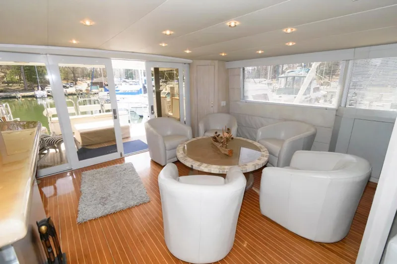 Liquidity Yacht Photos Pics Luxurious 1984 Broward Raised Pilothouse yacht interior with elegant seating and scenic marina view.