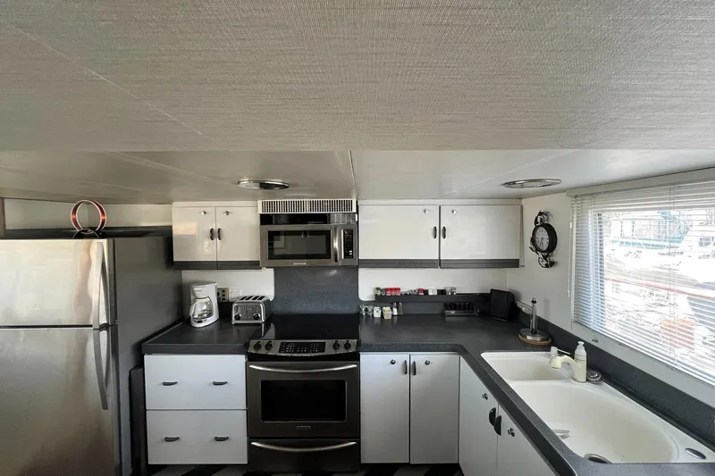 Liquidity Yacht Photos Pics 1984 Broward Raised Pilothouse kitchen with modern appliances and sleek cabinetry.
