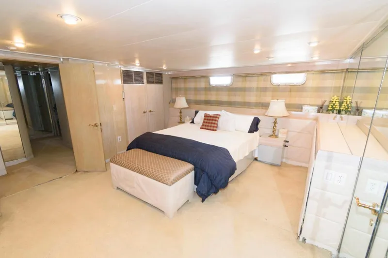 Liquidity Yacht Photos Pics Luxurious bedroom in 1984 Broward Raised Pilothouse yacht with elegant decor and cozy ambiance.