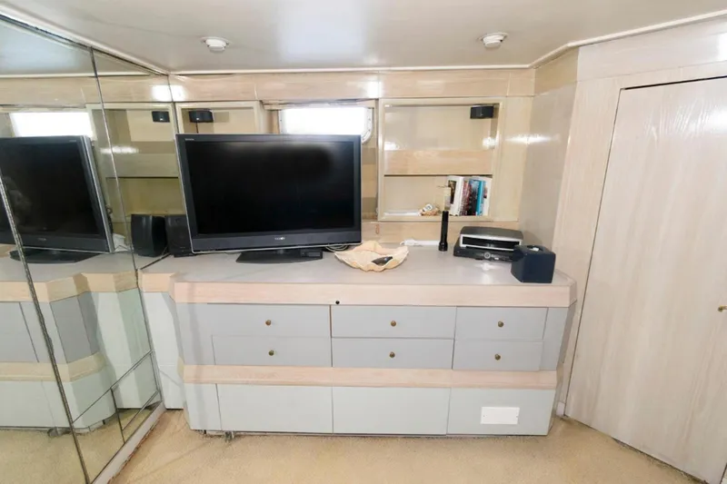 Liquidity Yacht Photos Pics 1984 Broward Raised Pilothouse interior with TV, mirrored walls, and modern cabinetry.