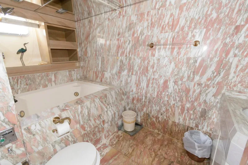 Liquidity Yacht Photos Pics Luxurious marble bathroom in 1984 Broward Raised Pilothouse yacht, featuring bathtub and elegant fixtures.
