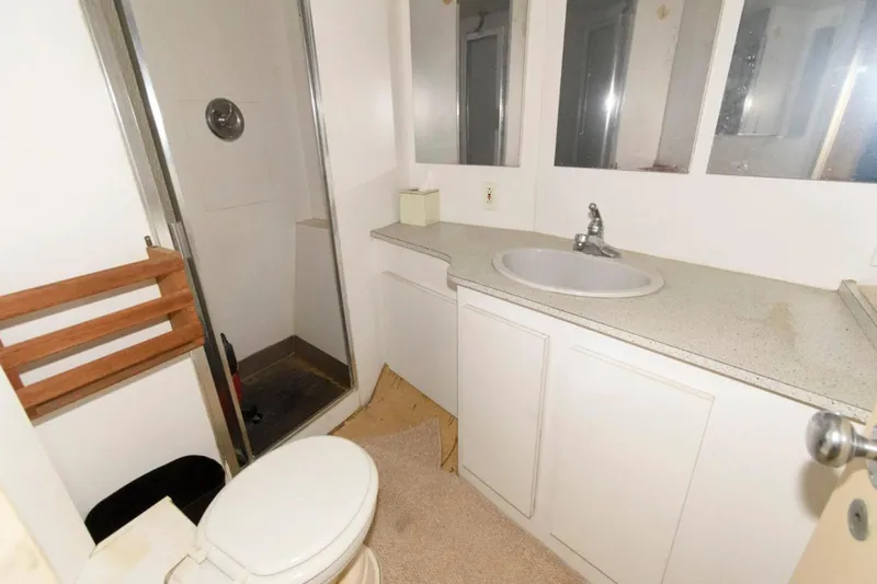 Liquidity Yacht Photos Pics Bathroom interior of 1984 Broward Raised Pilothouse yacht with shower and sink.
