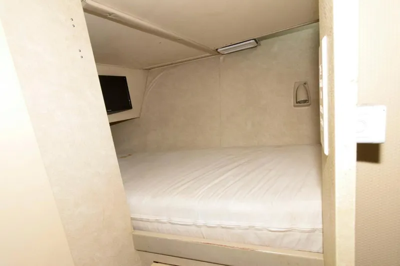 Liquidity Yacht Photos Pics Cozy cabin interior of 1984 Broward Raised Pilothouse yacht with bed and TV.