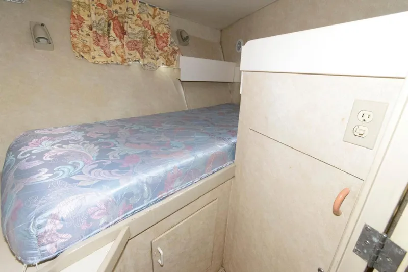 Liquidity Yacht Photos Pics 1984 Broward Raised Pilothouse cabin interior with bed, floral curtains, and storage.