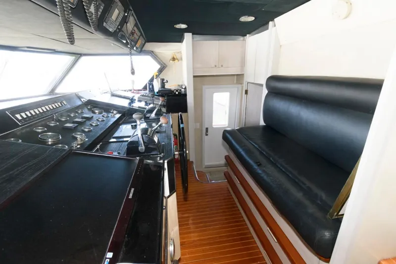 Liquidity Yacht Photos Pics 1984 Broward Raised Pilothouse interior with control panel and seating area.