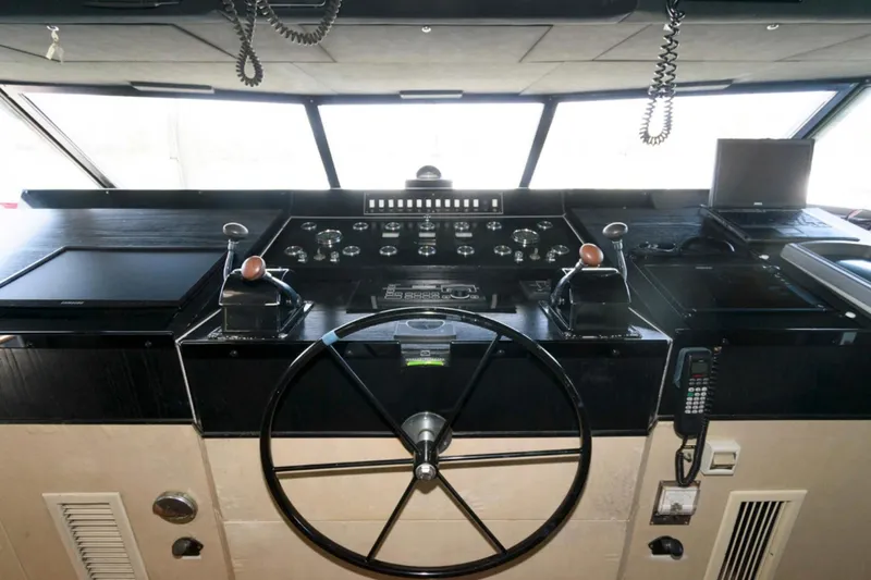 Liquidity Yacht Photos Pics 1984 Broward Raised Pilothouse yacht helm with steering wheel and control panels.
