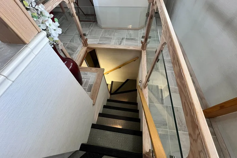 Liquidity Yacht Photos Pics Staircase with wooden railing on 1984 Broward Raised Pilothouse yacht interior.