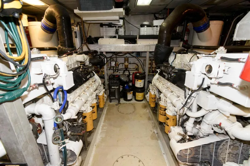 Liquidity Yacht Photos Pics Engine room of 1984 Broward Raised Pilothouse yacht with dual engines and maintenance equipment.