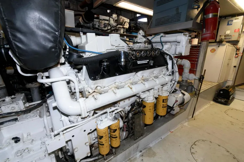 Liquidity Yacht Photos Pics Engine room of 1984 Broward Raised Pilothouse yacht, featuring complex machinery and equipment.