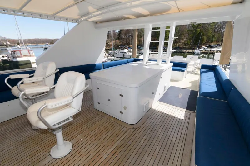 Liquidity Yacht Photos Pics Luxurious 1984 Broward Raised Pilothouse yacht deck with seating and helm chairs.