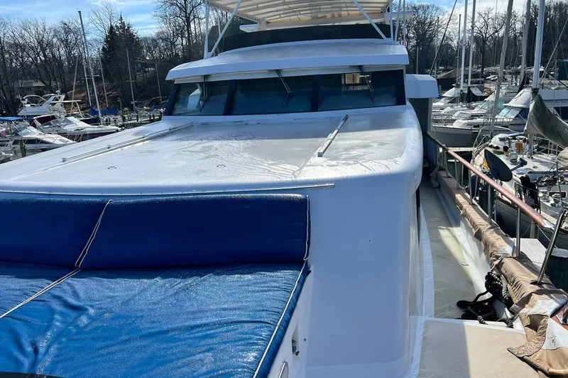 Liquidity Yacht Photos Pics 1984 Broward Raised Pilothouse yacht docked at marina, showcasing sleek design and spacious deck.