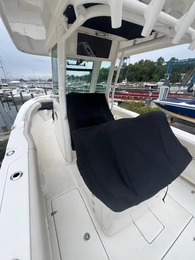  Yacht Photos Pics 2020 Boston Whaler 280 Outrage boat interior at marina, featuring covered seating and helm.
