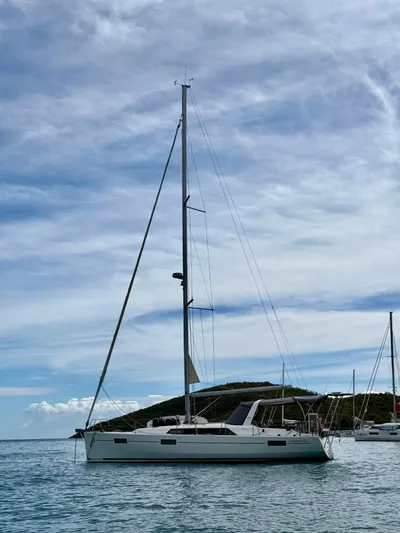 Wanderer Yacht Photos Pics 2019 Beneteau Oceanis 41.1 sailboat anchored in calm waters under a cloudy sky.