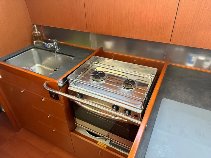 Wanderer Yacht Photos Pics 2019 Beneteau Oceanis 41.1 yacht kitchen with stove, sink, and wooden cabinetry.