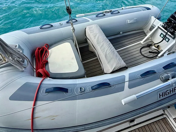 Wanderer Yacht Photos Pics Inflatable dinghy on Beneteau Oceanis 41.1, 2019 model, with red rope and motor, on blue water.