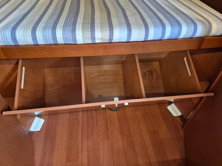 Wanderer Yacht Photos Pics Beneteau Oceanis 41.1 (2019) cabin storage with striped cushion and wooden compartments.