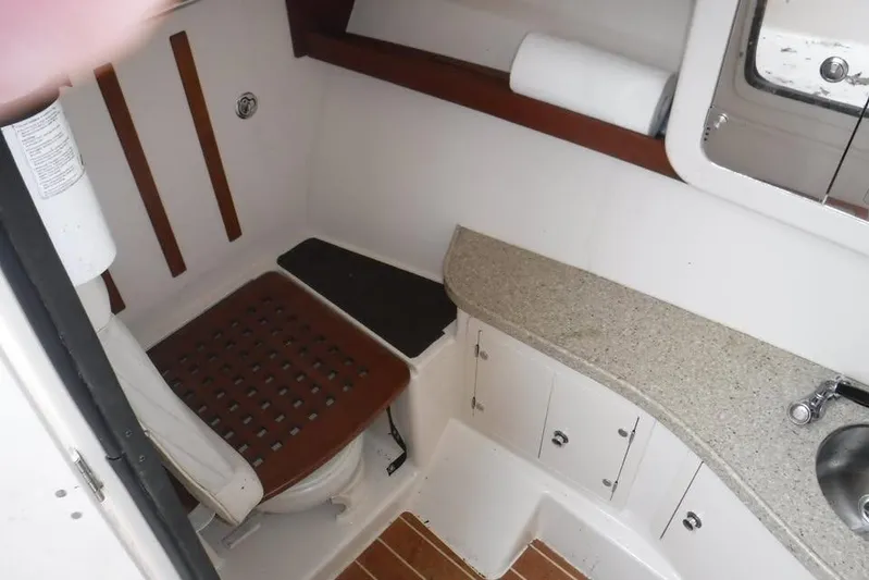  Yacht Photos Pics 2014 Grady-White Freedom 335 boat bathroom with toilet, sink, and storage cabinets.
