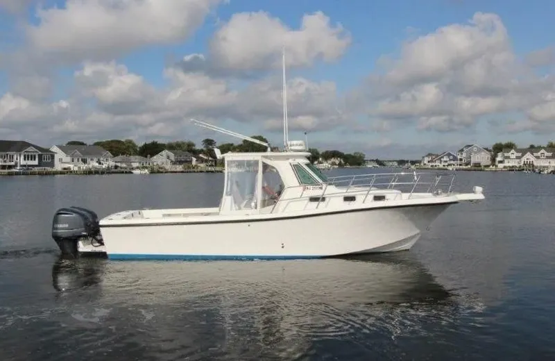 No Name Yacht Photos Pics 2015 True World Marine TE 289 boat on calm water, with houses in the background.