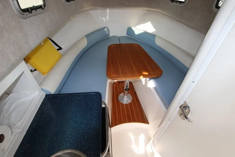 No Name Yacht Photos Pics 2015 True World Marine TE 289 cabin interior with seating and wooden table.