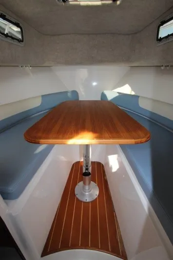 No Name Yacht Photos Pics 2015 True World Marine TE 289 cabin interior with wooden table and blue seating.