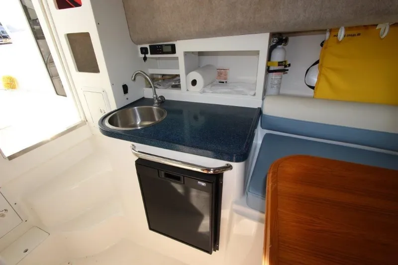 No Name Yacht Photos Pics 2015 True World Marine TE 289 interior with kitchenette, sink, and seating area.