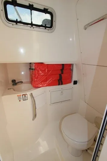 No Name Yacht Photos Pics 2015 True World Marine TE 289 boat bathroom with toilet, sink, and life jackets.