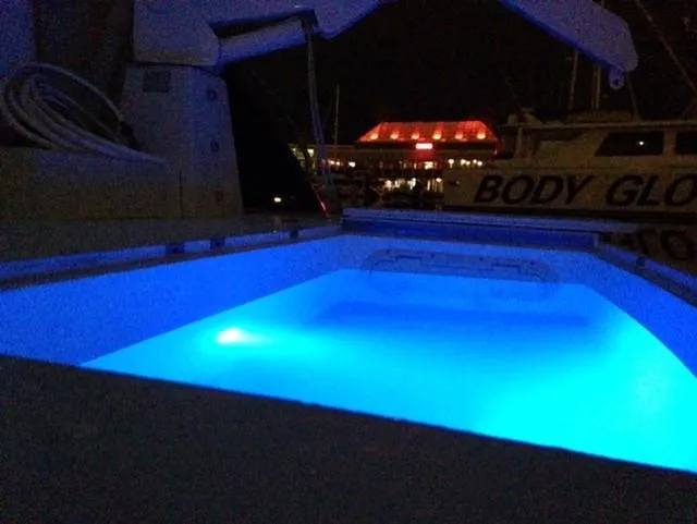The Enterprise Yacht Photos Pics Sunseeker MANHATTAN 1995 yacht with illuminated blue pool at night.