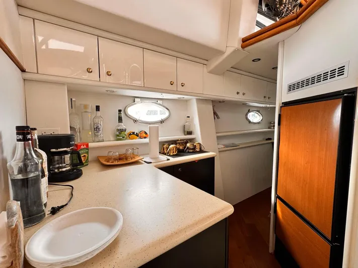 The Enterprise Yacht Photos Pics Interior of 1995 Sunseeker MANHATTAN yacht kitchen with modern amenities and wooden cabinetry.
