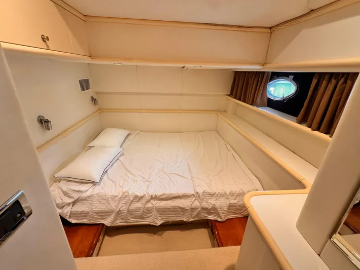 The Enterprise Yacht Photos Pics Cozy bedroom in 1995 Sunseeker MANHATTAN yacht with double bed and porthole window.