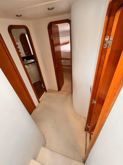 The Enterprise Yacht Photos Pics Interior hallway of a 1995 Sunseeker Manhattan yacht with wooden doors and carpeted floor.