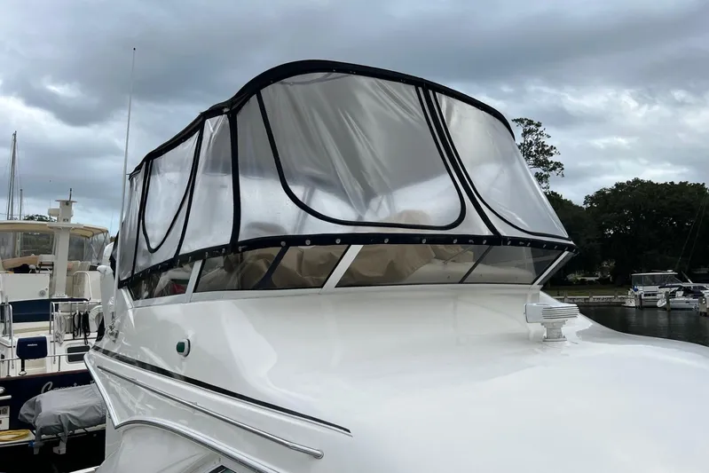  Yacht Photos Pics 2000 Sea Ray 400 Sedan Bridge with clear enclosure, docked under cloudy skies.