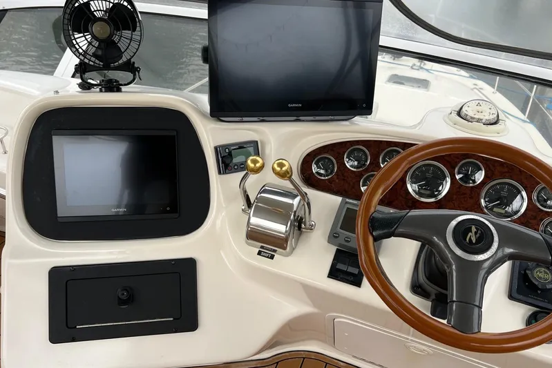  Yacht Photos Pics Control panel of a 2000 Sea Ray 400 Sedan Bridge with steering wheel and navigation screens.