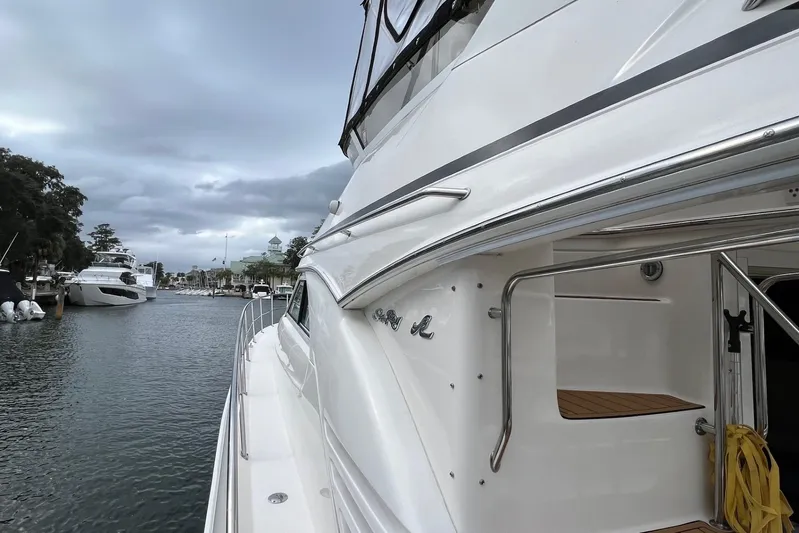  Yacht Photos Pics 2000 Sea Ray 400 Sedan Bridge yacht docked in a marina under cloudy skies.