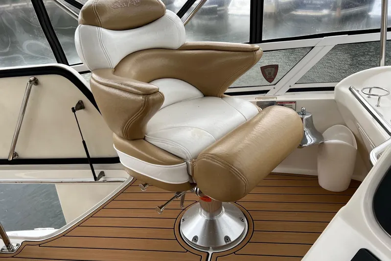  Yacht Photos Pics Captain's chair on 2000 Sea Ray 400 Sedan Bridge yacht, featuring tan and white upholstery.