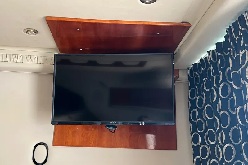  Yacht Photos Pics Flat-screen TV mounted on a wooden panel inside a 2000 Sea Ray 400 Sedan Bridge.