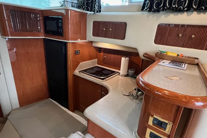  Yacht Photos Pics 2000 Sea Ray 400 Sedan Bridge yacht kitchen with wood cabinetry and modern appliances.